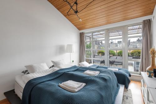 赫尔辛基WeHost Penthouse Studio with Sauna and Balcony @Meritullinkatu 13 A的一间卧室配有一张大床和两条毛巾