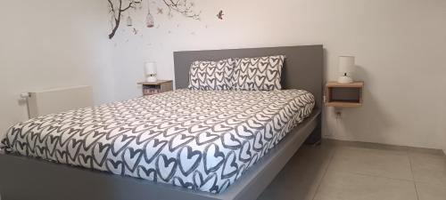 艾瓦耶Au Paradis d'Ayli的一间卧室配有一张带黑白色棉被的床