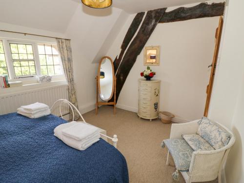 拉特沃思Millstone House的一间卧室配有蓝色的床、椅子和镜子