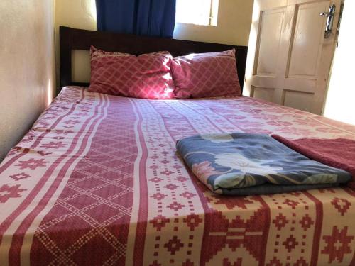 希莫尤Residencial Meu Tio的床上有红白毯子