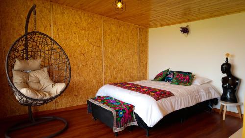 派帕Meraki_Paipa的一间卧室配有一张床和一把秋千椅