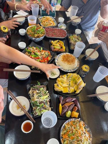 萨帕Thạch Gia Trang Sapa的一张长桌,上面放着许多盘子的食物