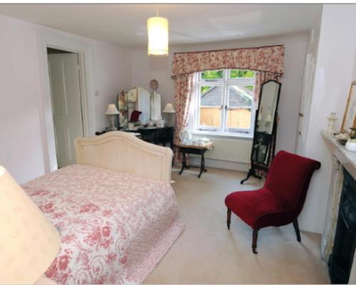 HolmwoodBlackbrook House的卧室配有床、椅子和窗户。