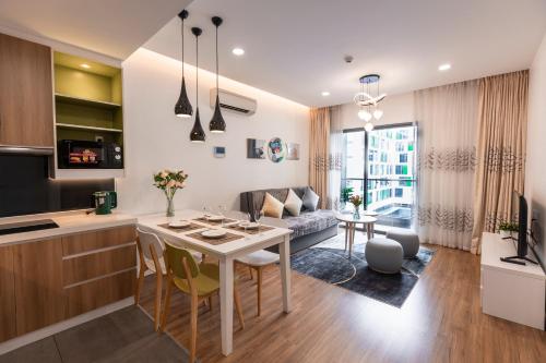胡志明市Republic Apartments Saigon Airport的厨房以及带桌子和沙发的客厅。