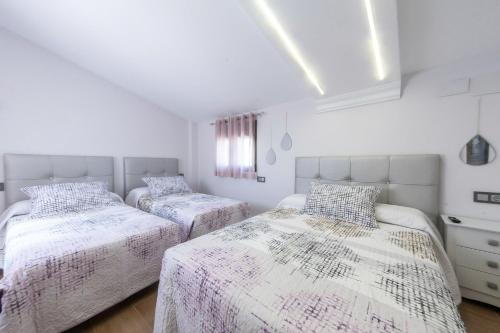 比利亚卡里略VTAR Puerta Del Sol的卧室设有2张床和白色的墙壁。