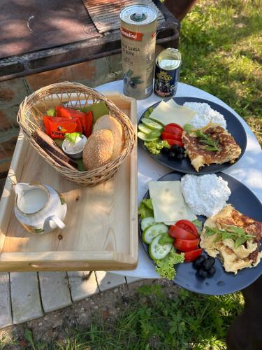 Lauku māja Sprīdīši的野餐桌,带两盘食物和一篮子