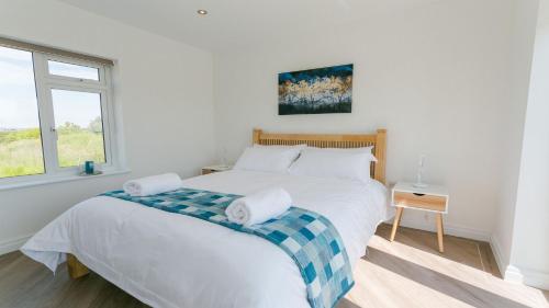 LlanfaelogNyth y Gwdihw的卧室设有一张白色大床和一扇窗户。