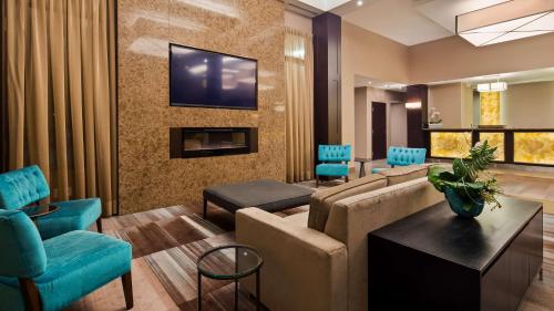 伦敦莱姆布莱特尔旅馆及会议中心贝斯特韦斯特PLUS酒店的客厅配有沙发和墙上的电视