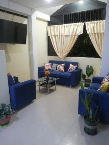 廷戈玛丽亚El Jardín de la Bella的客厅配有蓝色的沙发和电视