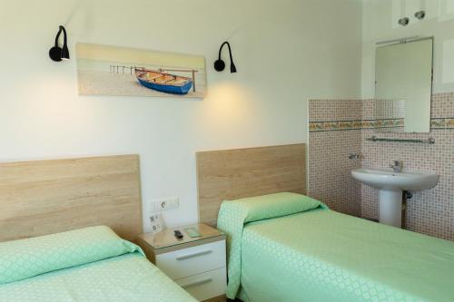 卡门港Hostal Magec的浴室设有两张床、一个水槽和水槽