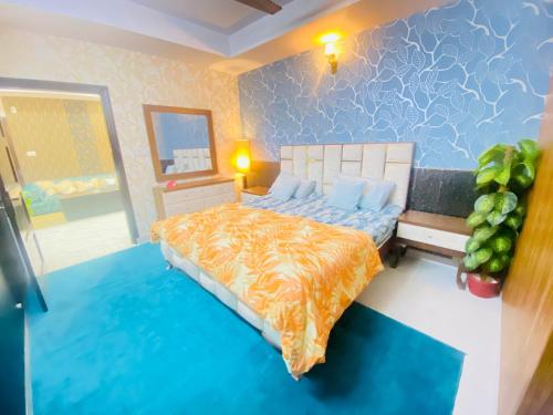 伊斯兰堡Viceroy Luxury Hotel Apartments Islamabad的一间卧室配有一张带橙色和蓝色棉被的床