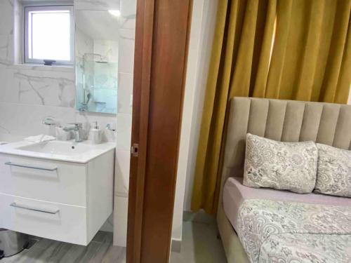 圣多明各Elegant City Center Condo的浴室设有床、水槽和镜子