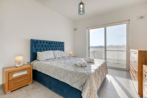 比尔基卡拉Annitchka Mansions - Penthouse in central Malta的一间卧室配有一张大床和蓝色床头板