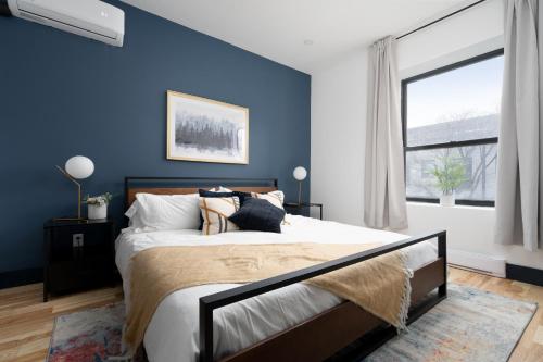 蒙特利尔Les Suites Saint-Laurent的一间卧室拥有蓝色的墙壁,配有一张带枕头的床。