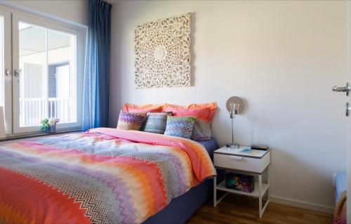 斯德哥尔摩Fresh and cosy apartment in the center of the city的一间卧室配有一张色彩缤纷的床和一扇窗户