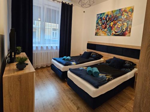 凯尔采Apartamenty KoktajLOVE的一间设有两张床的房间,位于一个画室