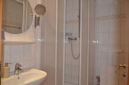 萨斯尼茨Fürstenhof - Ferienwohnung 403的带淋浴、盥洗盆和镜子的浴室