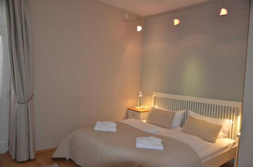 萨斯尼茨Fürstenhof - Ferienwohnung 203的卧室配有白色的床和2条毛巾