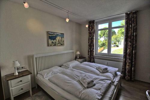 萨斯尼茨Villa Seeblick Apartment 307的一间卧室设有一张大床和一个窗户。