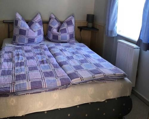 MarlowFerienhaus Karger的卧室内的一张带紫色枕头的床