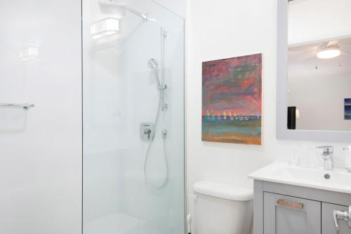 乔治敦Snug Harbour View Condo #8的带淋浴和盥洗盆的白色浴室