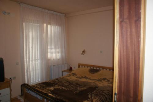 斯特鲁加Jovanoski Apartments的一间卧室设有一张床和一个窗口