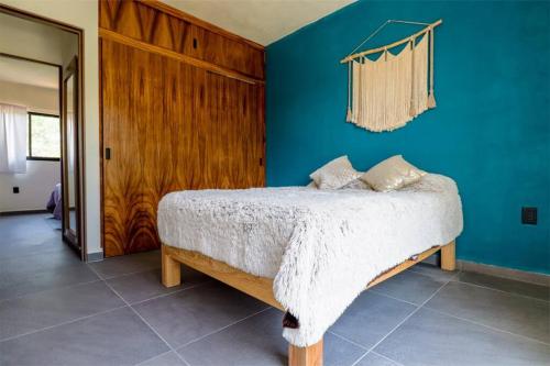 巴亚尔塔港Condo Temis Vallarta的一间卧室设有一张床和蓝色的墙壁