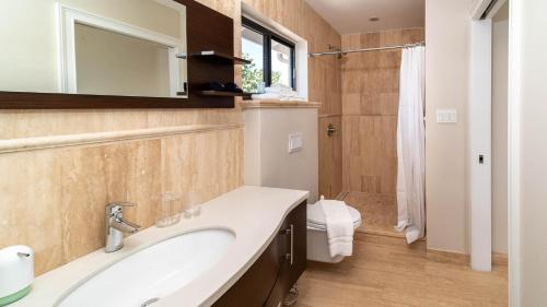 西湾Seven Mile View Condo #1的一间带水槽、卫生间和镜子的浴室