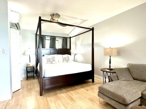 西湾Seven Mile View Condo #3B的一间卧室配有天蓬床和沙发
