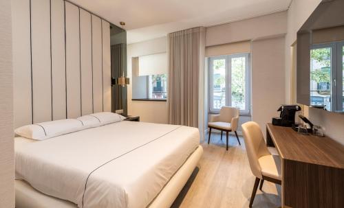 里斯本AMMA Lisboa Hotel的酒店客房配有一张床、一张书桌和一台电脑