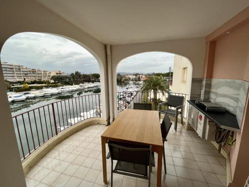曼德琉-拉纳普勒Studio moderne - Port de Mandelieu - Proche Mer的阳台配有桌子,享有海港景色