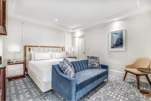 温哥华AZUR Legacy Collection Hotel的一间卧室配有一张床和一张蓝色椅子