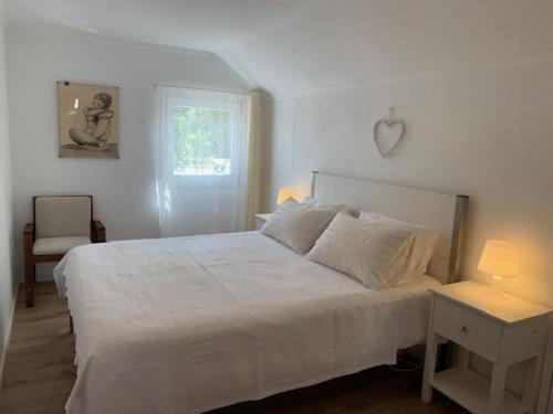 辛特拉Andar tranquilo entre Lisboa Sintra的卧室设有一张白色大床和一扇窗户。