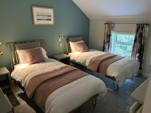 IrvinestownCastle Irvine Estate的一间卧室设有两张床和窗户。