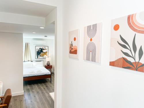 洛杉矶Cozy Habitat的卧室配有一张床,墙上挂有绘画作品