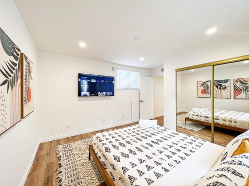 洛杉矶Comfy 2-bedroom home in Hollywood的卧室配有一张床,墙上配有电视。