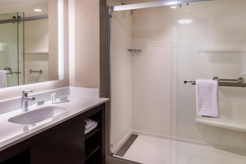 西雅图西雅图大学区万豪原住客栈的一间带水槽和玻璃淋浴的浴室
