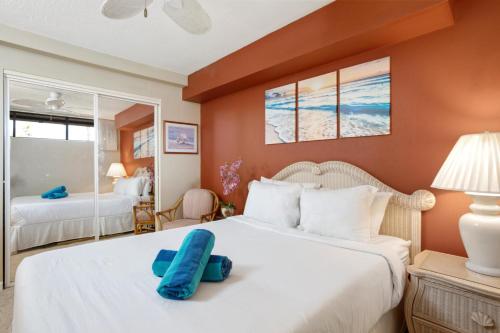 卡纳帕利KBM Resorts KVR-F405 1 bdrm Includes Rental Car的一间卧室配有一张大床,上面有蓝色的枕头