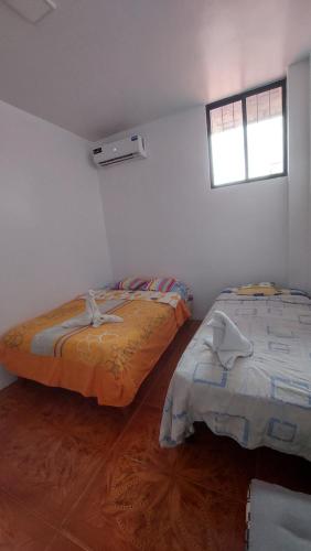 巴克里索莫雷诺港CASA DE NOELIA的白色客房的两张床,设有窗户