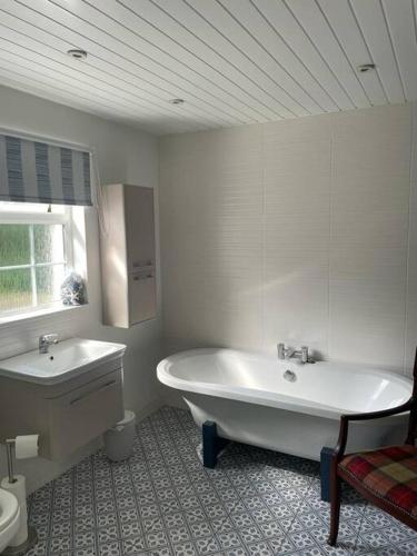 CastledawsonMillview Cottage的白色的浴室设有浴缸和水槽。