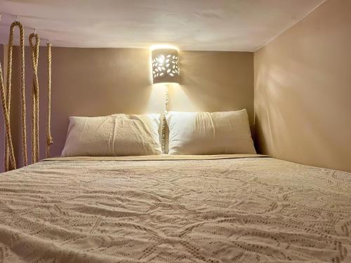 塔姆拉赫特乌兹达尔Desart Hostel的一间卧室配有一张位于上面的光线的床