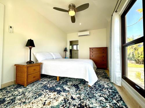 西湾Seven Mile View Condo #4的一间卧室配有一张带吊扇和窗户的床。