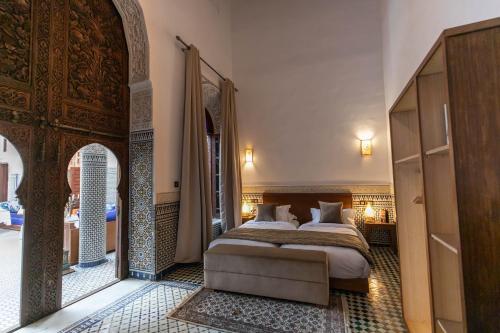 非斯Riad Fes Ziyat & Spa的一间卧室设有一张床和一个拱形门廊