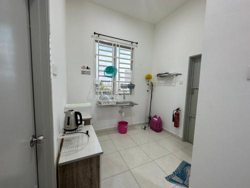 Guar ChempedakHomestay Cermai Indah Guar Chempedak的白色的浴室设有水槽和窗户。