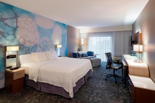 MoosicCourtyard by Marriott Scranton Montage Mountain的酒店客房配有一张床、一张书桌和一张沙发。