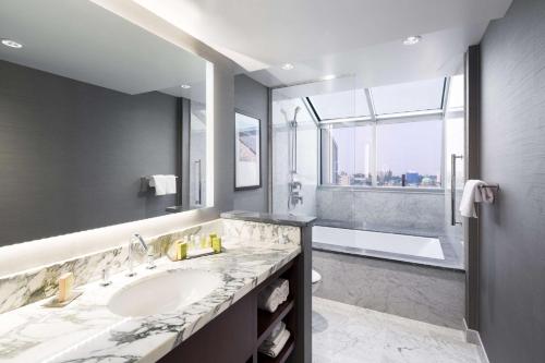 维多利亚维多利亚希尔顿逸林套房酒店的一间带水槽和大窗户的浴室
