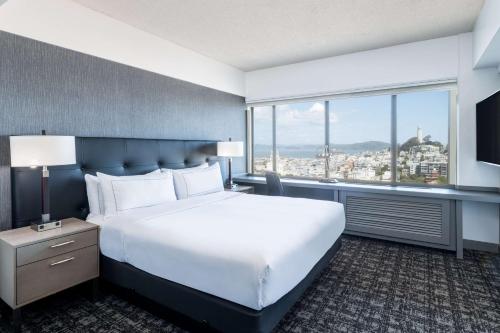 旧金山希尔顿旧金山金融区酒店的一间卧室设有一张大床和一个大窗户