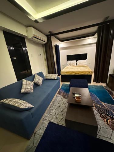 沙姆沙伊赫Villa Silia的一间设有两张床和蓝色沙发的房间