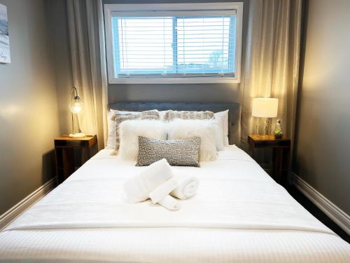 伦敦The Capri Suite in Old South London的卧室配有一张白色大床和两条毛巾