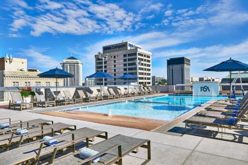 蒙哥马利蒙哥马利会议中心万丽Spa酒店的一座大楼的顶部,设有一座带椅子和遮阳伞的游泳池